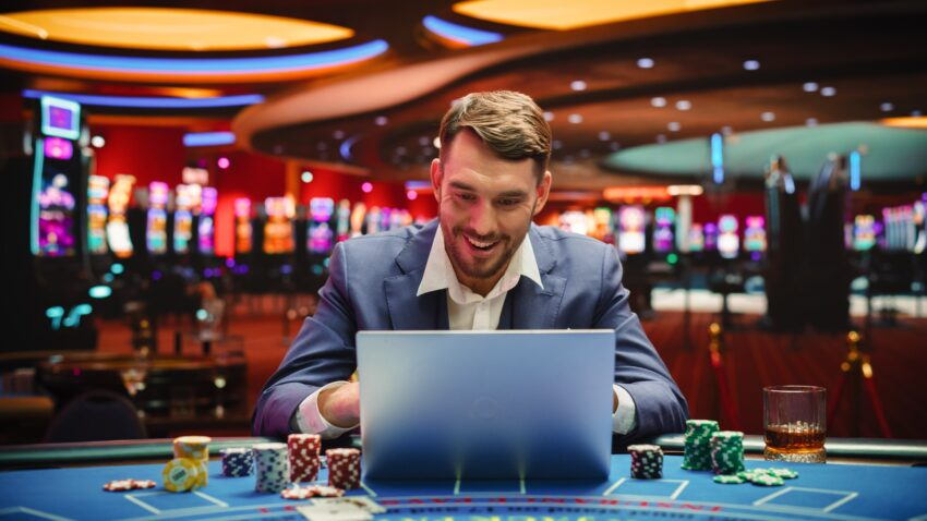 guy on laptop in a casino logging into crypto casinos